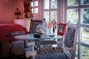 Relax in this inviting room with a round table, zebra-striped chairs, and a large window.