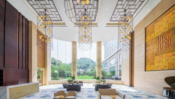 A spacious lobby with modern furniture, large windows, and decorative lighting. - Nanyue Resort (Huoshan)