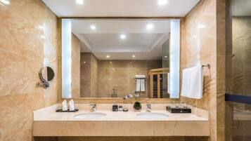 Un baño moderno con dos lavamanos, un espejo grande y un box de ducha de vidrio.