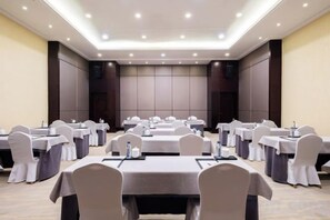 A conference room with multiple tables and chairs, equipped with microphones and water bottles. - Nanyue Resort (Huoshan)
