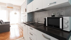 A modern kitchen with a built-in microwave, a sink, and a coffee machine. - Italianway Collection - Cannobio 8 - Trovatore (Milan)