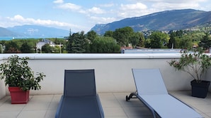 Two lounge chairs on a tiled terrace with a view of mountains and a body of water. - Aix-les-Bains Grand Port T2 Furnished 3 Stars Terrace 57m2 (Aix-les-Bains)