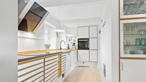 A modern kitchen with white cabinetry, wooden countertops, and a built-in oven. - Stunning home in Nørre Nebel (Nørre Nebel)
