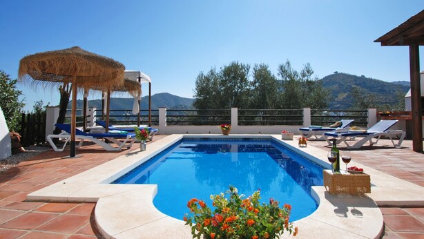 A swimming pool with lounge chairs and umbrellas, surrounded by a terrace with a view of hills. - Torcal 1 - Magnificent Villa for 8 People, Heated Pool, A/C, WIFI, Pet friendly! (Comares)