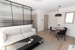 A modern living room with a sofa, a coffee table, and a dining area with chairs and a table. - Modern apartment close to Athens city center (Form_F2) (Βύρωνας)