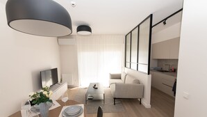 Een moderne woonkamer met een bank, salontafel en een eethoek.