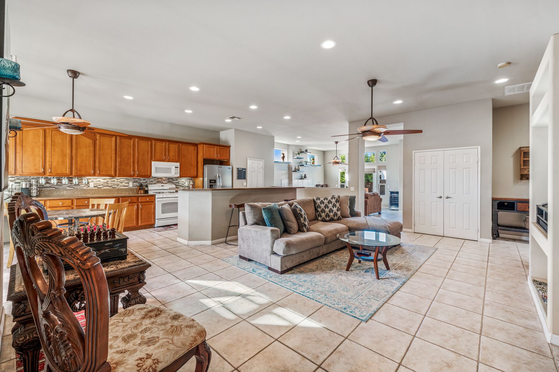 A spacious living area with a sofa, coffee table, and wooden dining table.