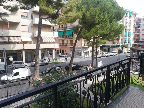 A residential area with multi-story buildings, a street with parked cars, and a pedestrian crossing.