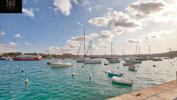 A marina with various boats docked, a large ship in the background, and a clear sky. - Designer APT on Sliema Promenade, Perfect Location (Tas-Sliema)