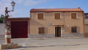 Un edificio con una porta rossa, due finestre e un cartello che indica un servizio pubblico.