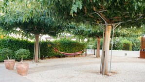 A garden area with a pergola, a hammock, and potted plants. - On the beach house latsi (Poli Crysochous)