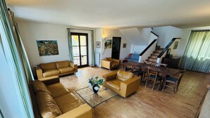 A spacious living room with a sofa set, a coffee table, and a dining area with chairs and a table. - Villa seaview and private pool (Torrevecchia Teatina)
