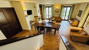 A dining area with a wooden table and chairs, a sofa, and a television. - Villa seaview and private pool (Torrevecchia Teatina)
