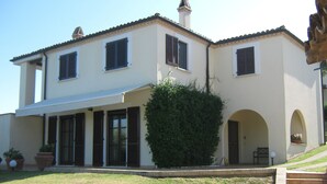 A two-story house with a covered patio, a well-maintained lawn, and a large hedge. - Villa seaview and private pool (Torrevecchia Teatina)