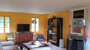 Ein Wohnzimmer mit Fernseher, Holzmöbeln, einem Bücherregal und einem Kamin.