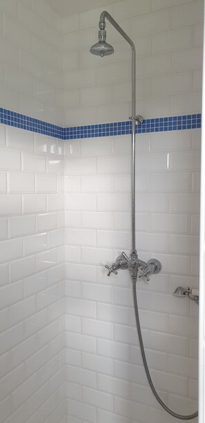 Een douche, een haardroger, handdoeken, toiletpapier