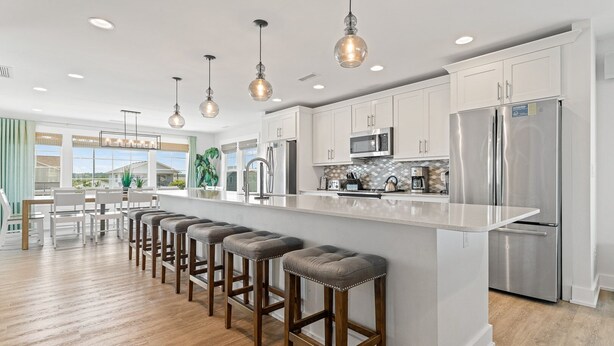 A modern kitchen with a central island, stainless steel appliances, and pendant lighting. - Lotus House Pets Stay Free +Private Pool (Kill Devil Hills)