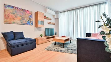 Un salon moderne comprenant un canapé, une table basse, un téléviseur et des objets décoratifs.