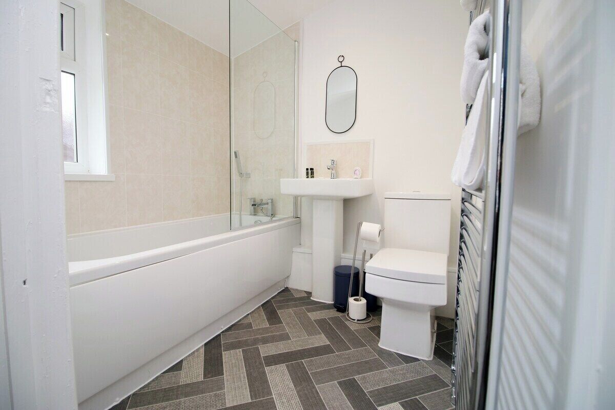 A modern bathroom with a bathtub, toilet, and sink.
