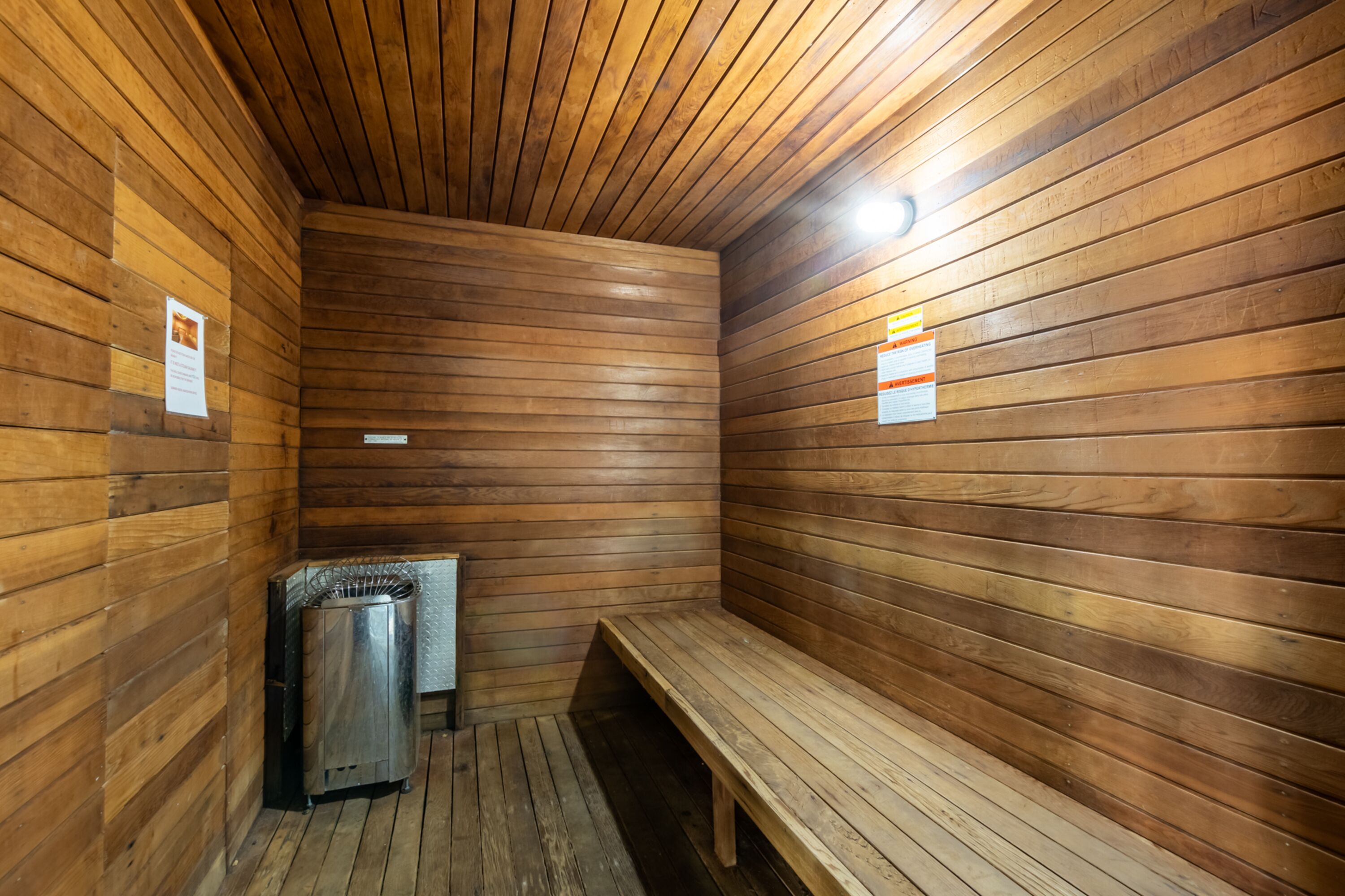 A sauna with wooden walls and a bench.