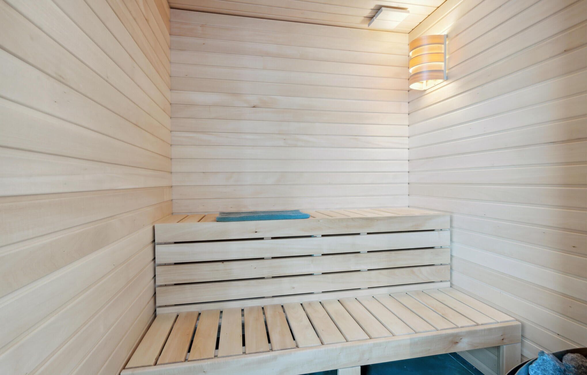 A sauna with wooden benches and a blue mat.