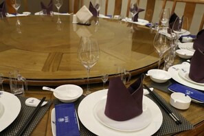 A round dining table with plates, glasses, and cutlery. - Songfulou Hotel (Qimen)