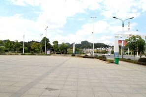 An open paved area with street lamps and a trash bin. - Songfulou Hotel (Qimen)