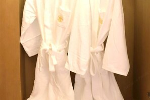 A white robe hanging on a wooden door. - Songfulou Hotel (Qimen)