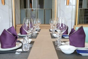 A dining table set with multiple wine glasses, plates, and folded napkins. - Songfulou Hotel (Qimen)