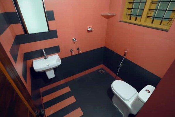 Un baño pequeño con un lavamanos blanco, un inodoro y una ducha.