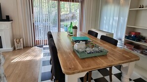 Ein Essbereich mit Schachbrettfußboden, einem Holztisch und Stühlen.