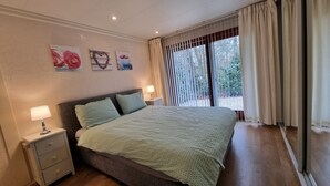 Ein Schlafzimmer mit einem Bett, Nachttischen und einem Fenster mit Vorhängen.
