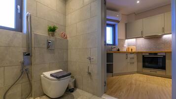 A modern bathroom with a shower, toilet, and sink.