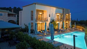 A two-story building with a swimming pool, outdoor seating, and a stone facade. - Kannas Mani-Luxury Suites- Adults friendly 14+ (West Mani)