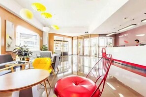 A modern hotel lobby with a reception desk, seating area, and a large window. - Shankee Hotel (Shanghai Jinshan Wanda) (Shanghai)