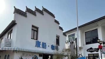 A traditional building with a white facade and multiple windows.