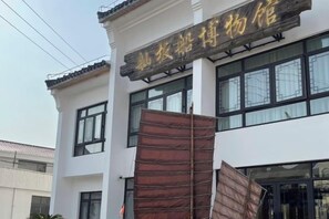 A building with a sign that reads 'Hotel' in gold lettering on a white background. - Shankee Hotel (Shanghai Jinshan Wanda) (Shanghai)