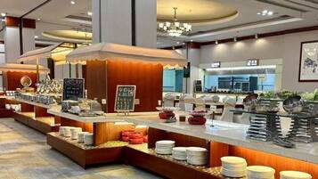 A buffet setup with multiple serving stations, a visible counter, and a seating area.