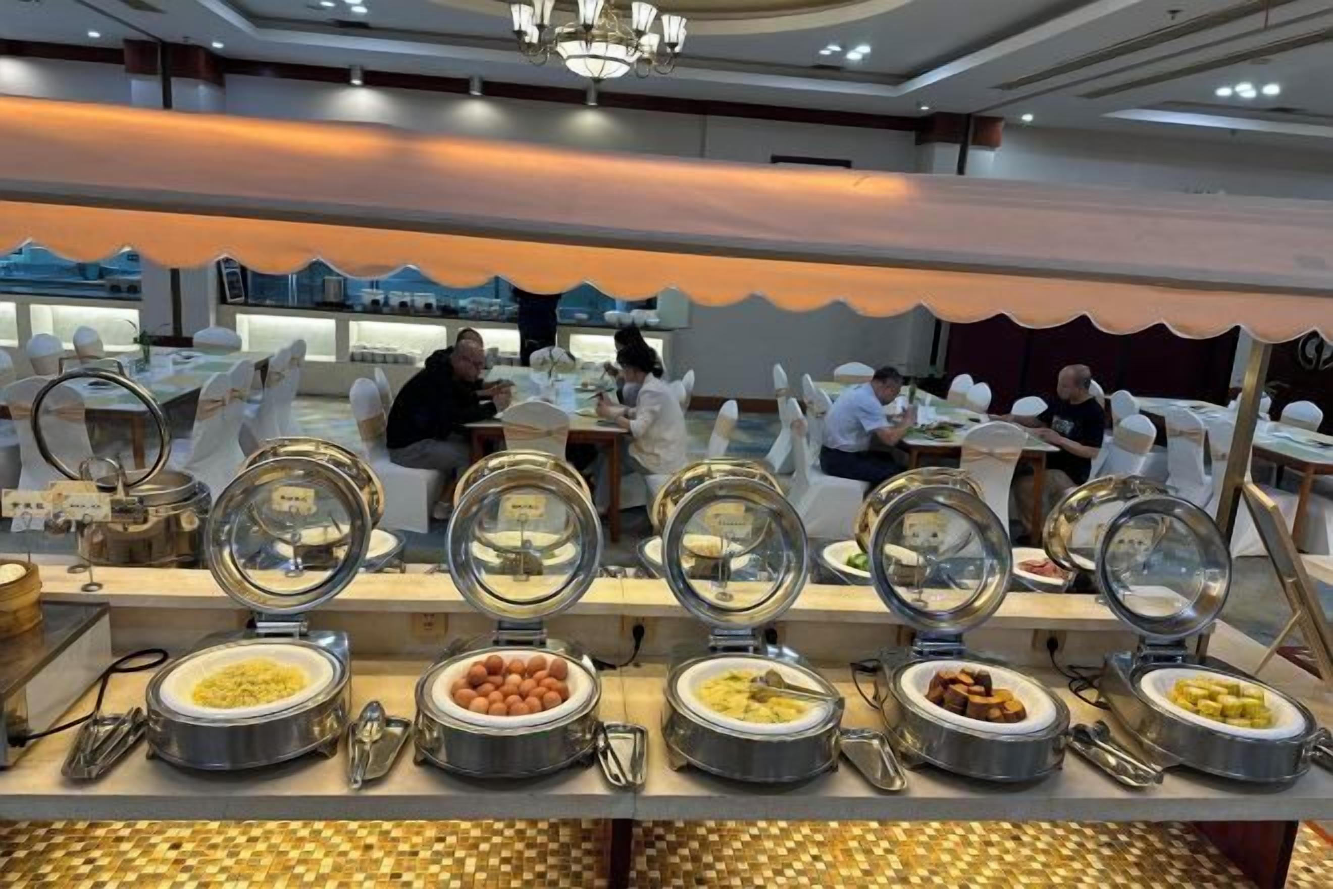 Disposição de buffet com várias estações de comida, incluindo uma variedade de pratos em recipientes de vidro.