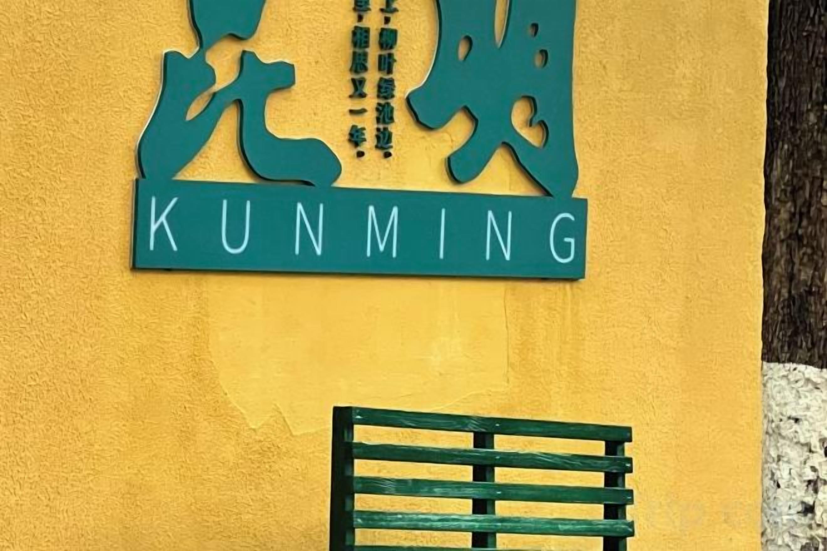 A sign with Chinese characters and the word 'KUNMING' in English.