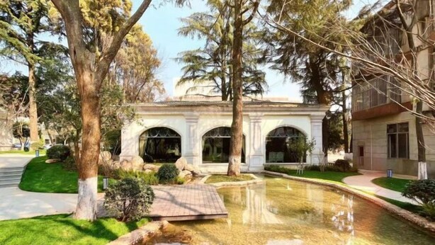 Ein Gebäude mit Bogenfenstern und einem zentralen Innenhof mit Wasserspiel.