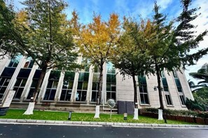 A modern building with large windows and a well-maintained lawn.