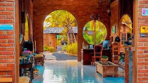 An indoor pool area with a brick archway, a ceiling fan, and a view of the outside. - Plaiphu Pool Villas (Kapong)