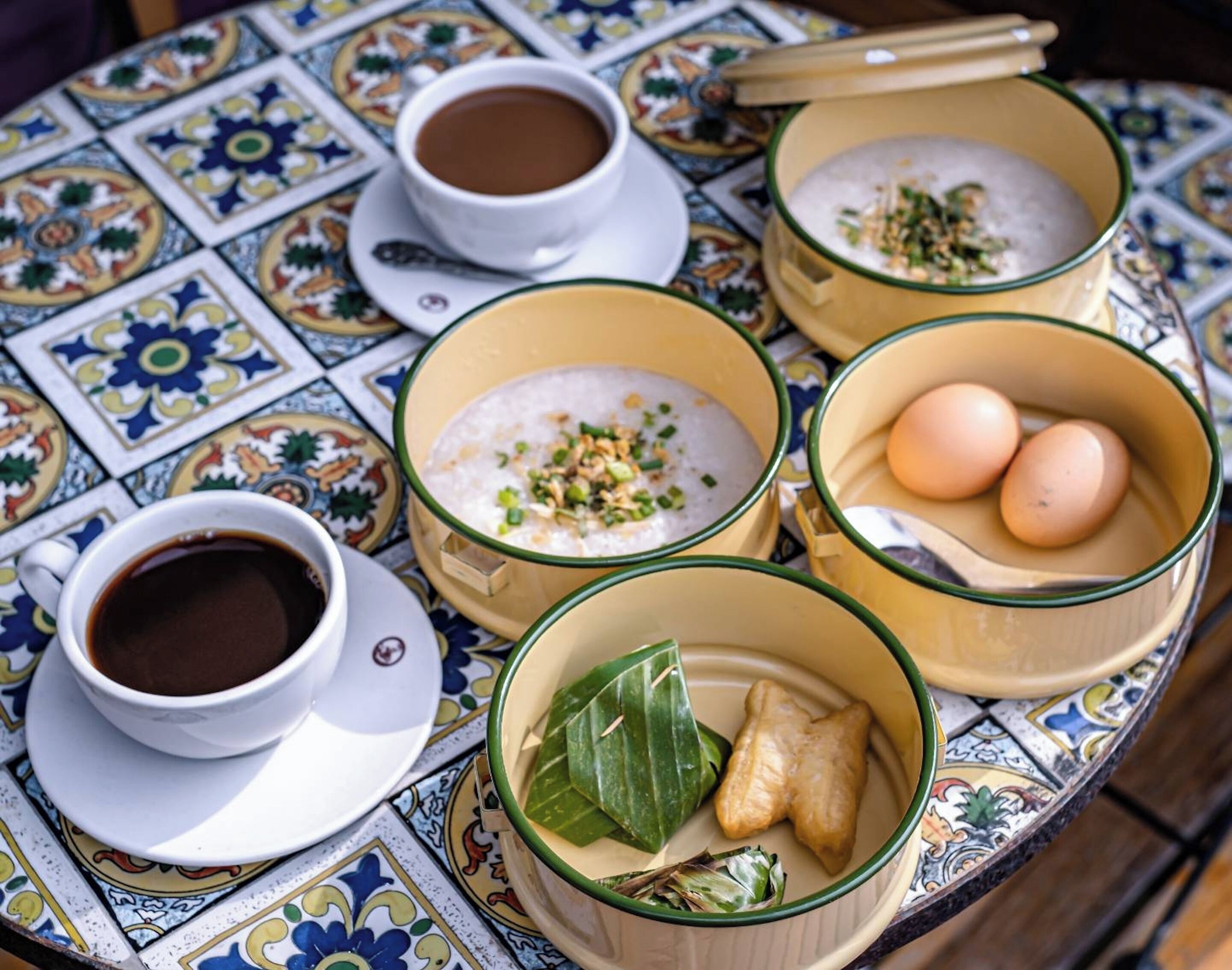 Une table où l’on trouve une variété de plats, notamment du riz, des œufs et une tasse de café.