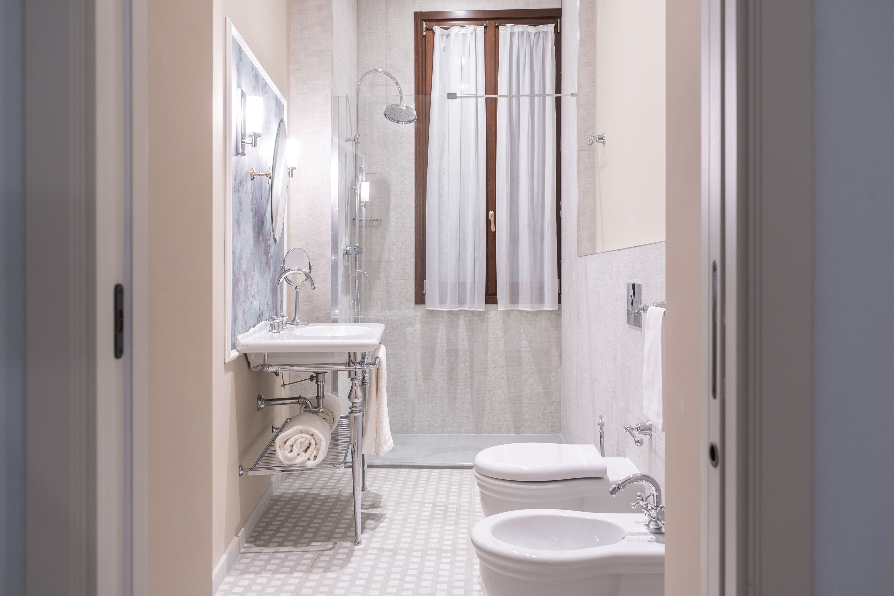 A bathroom with a shower, toilet, sink, and a mirror.