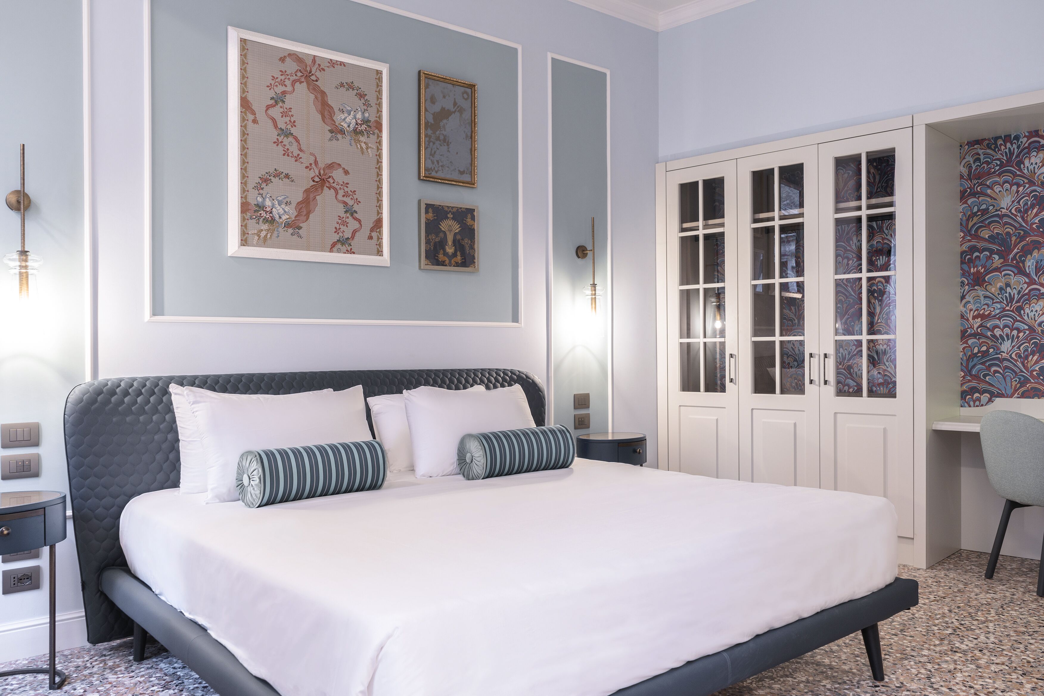 Un dormitorio ordenado con una cama grande, un escritorio y una silla.