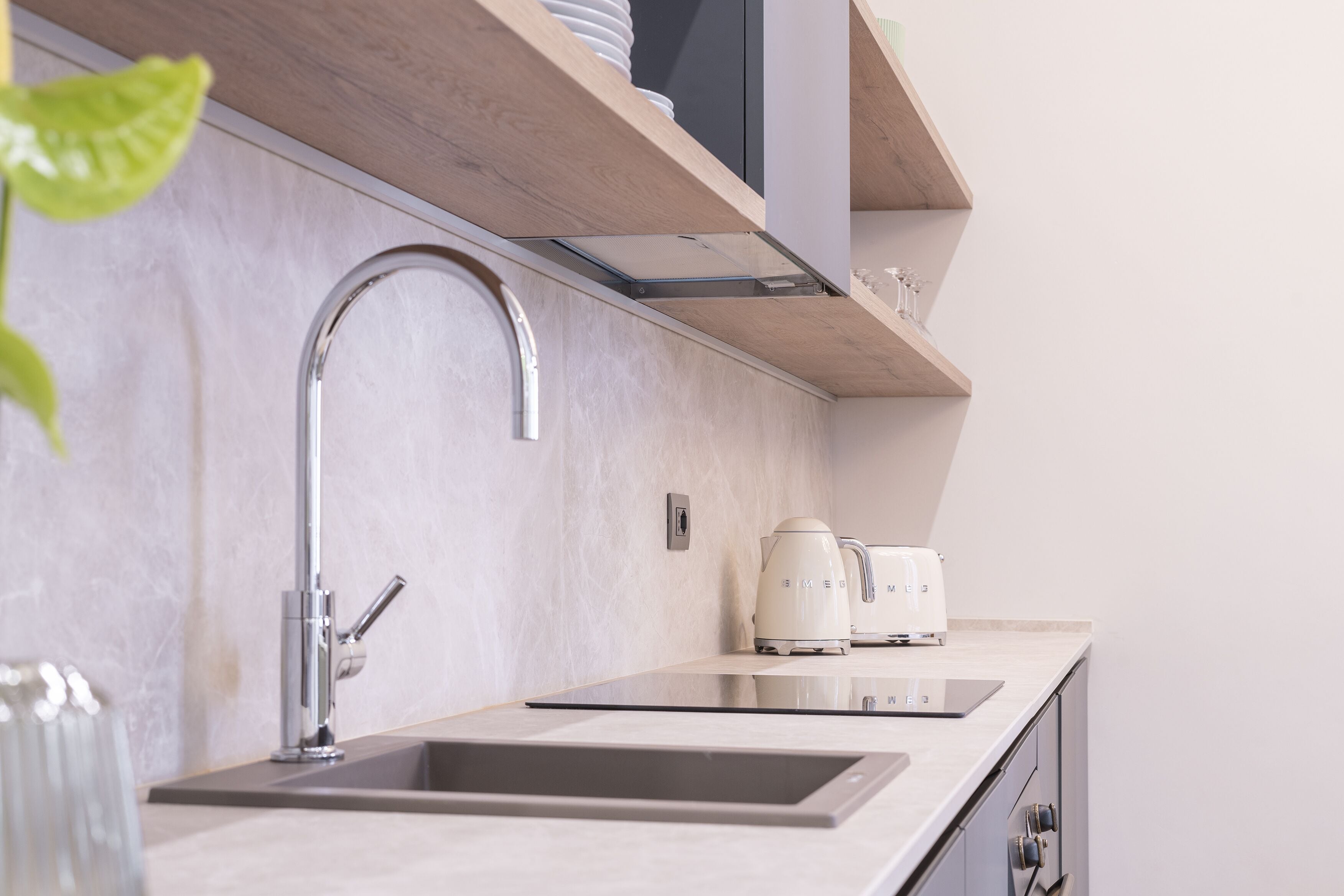 A modern kitchen with a stainless steel sink, a built-in oven, and a microwave.