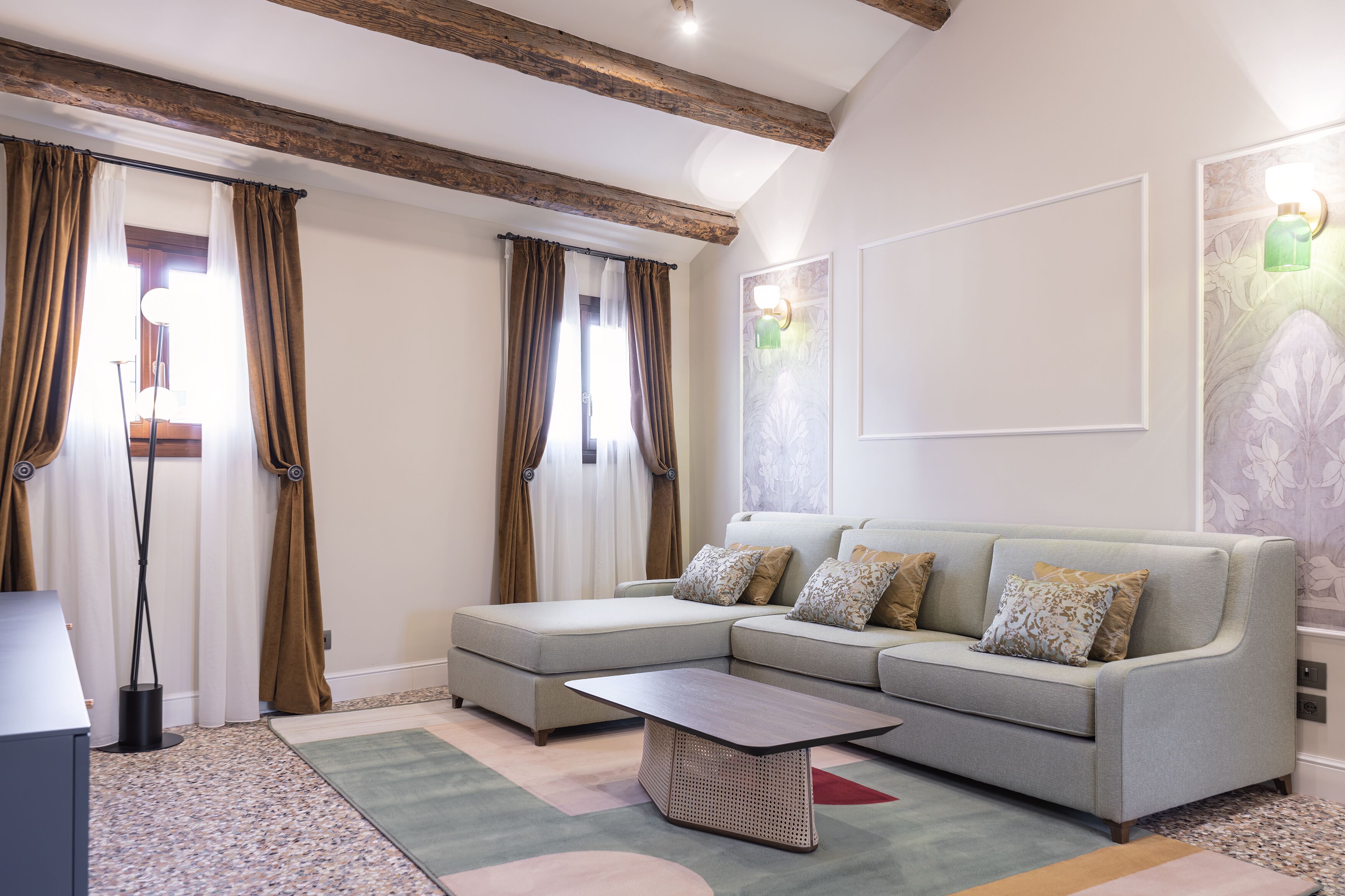 Un salon moderne avec un canapé d’angle, une table basse et un lampadaire.