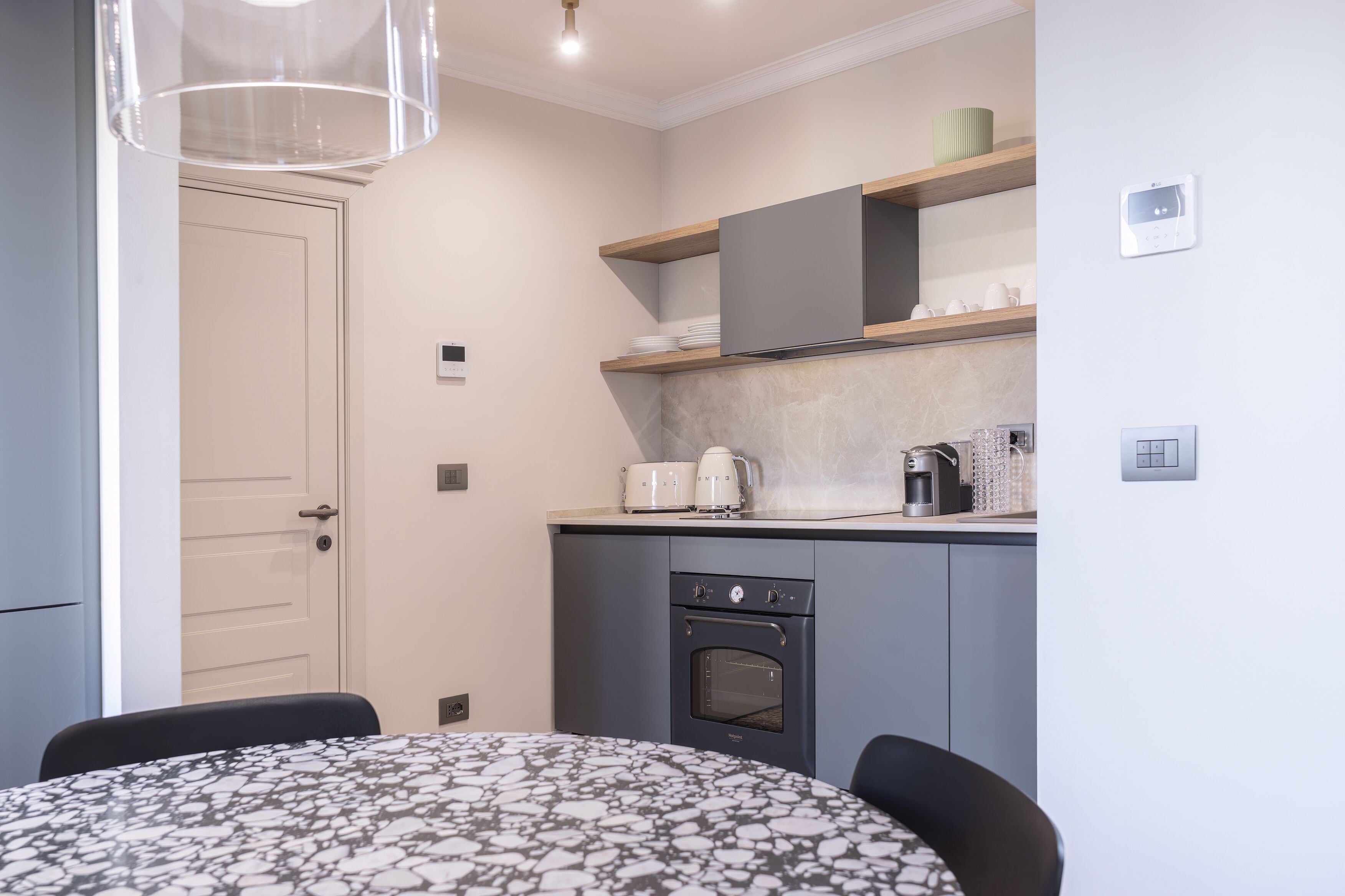 A compact kitchen with a built-in oven, a microwave, and a coffee maker on the countertop.