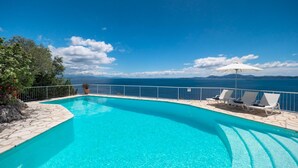 A clear blue pool with a view of the sea, surrounded by a stone deck and white railings. - The Saints - St Mathias 2 Bedroom Cottage (Corfu)